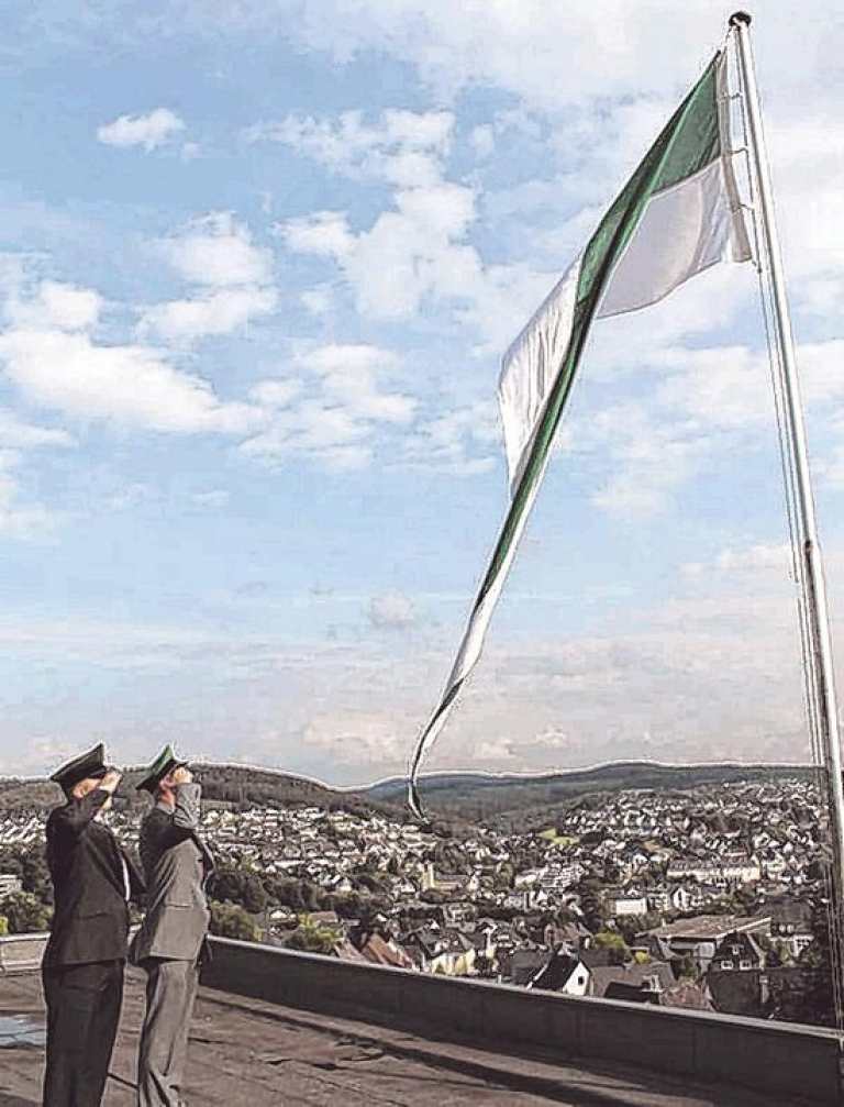 Stefan Immekus und Georg Arens (v. l.) hissten gestern Abend hoch über Olpe die Fahne als weithin sichtbares Zeichen: Das Schützenfest hat begonnen. Foto: hobö