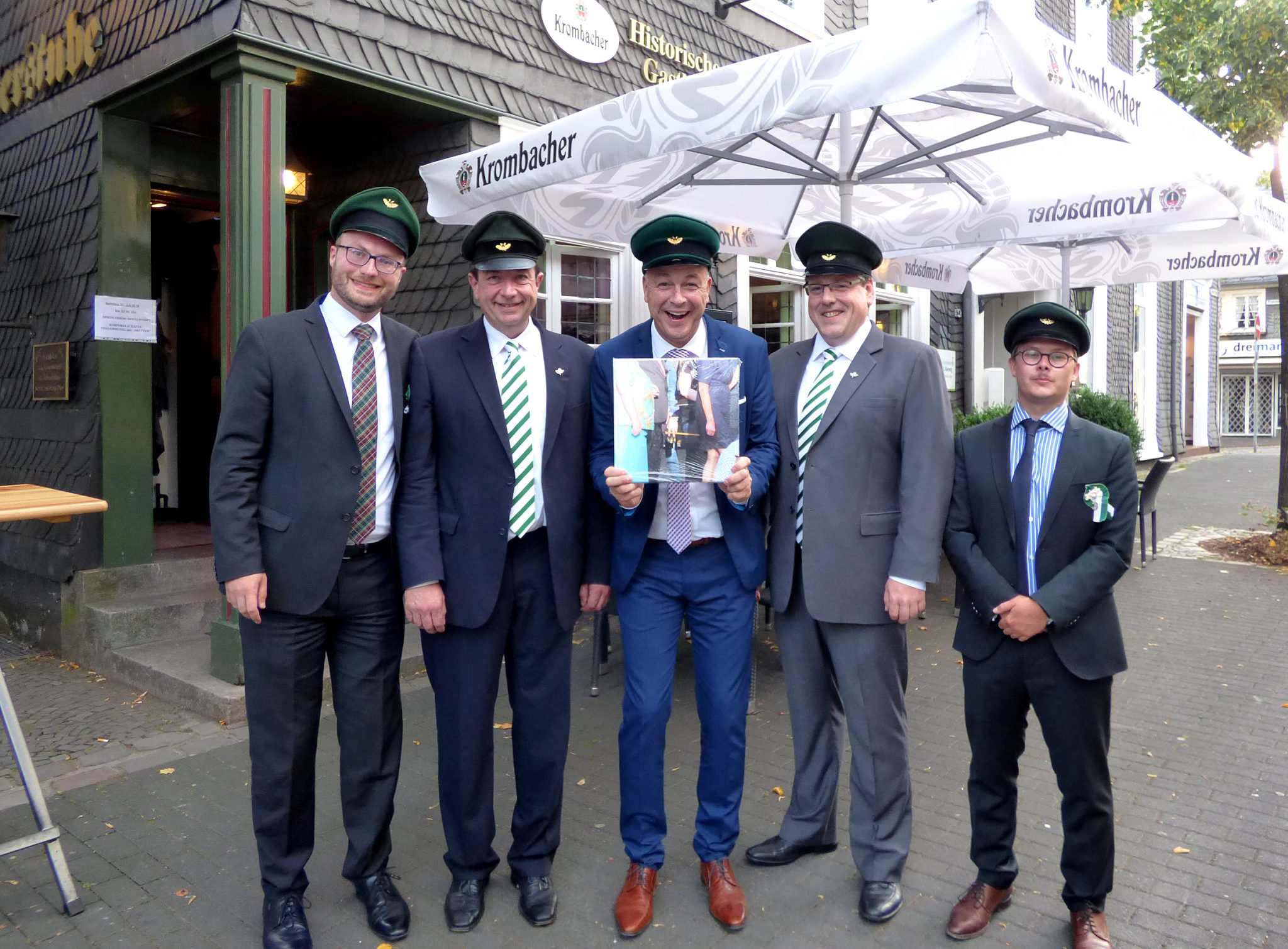 Bei der 3. Korporalschaft begann die Rundreise des Olper Schützenkönigs Rainer Brüser (m.) mit Major Peter Liese (2.v.l.) und Hauptmann Holger Harnischmacher (2.v.r.). Im Wachlokal „Tillmann“ erhielt der König von Korporalschaftsführer Eduard Köster (l.) und seinem Stellvertreter Louis Hütte (r.) das erste Quadrat des Gemeinschaftsgeschenks der neun Korporalschaften, ein Teil des Lieblingsfotos des Olper Königspaares. Foto: mari Bei der 3. Korporalschaft begann die Rundreise des Olper Schützenkönigs Rainer Brüser (m.) mit Major Peter Liese (2.v.l.) und Hauptmann Holger Harnischmacher (2.v.r.). Im Wachlokal „Tillmann“ erhielt der König von Korporalschaftsführer Eduard Köster (l.) und seinem Stellvertreter Louis Hütte (r.) das erste Quadrat des Gemeinschaftsgeschenks der neun Korporalschaften, ein Teil des Lieblingsfotos des Olper Königspaares. Foto: mari