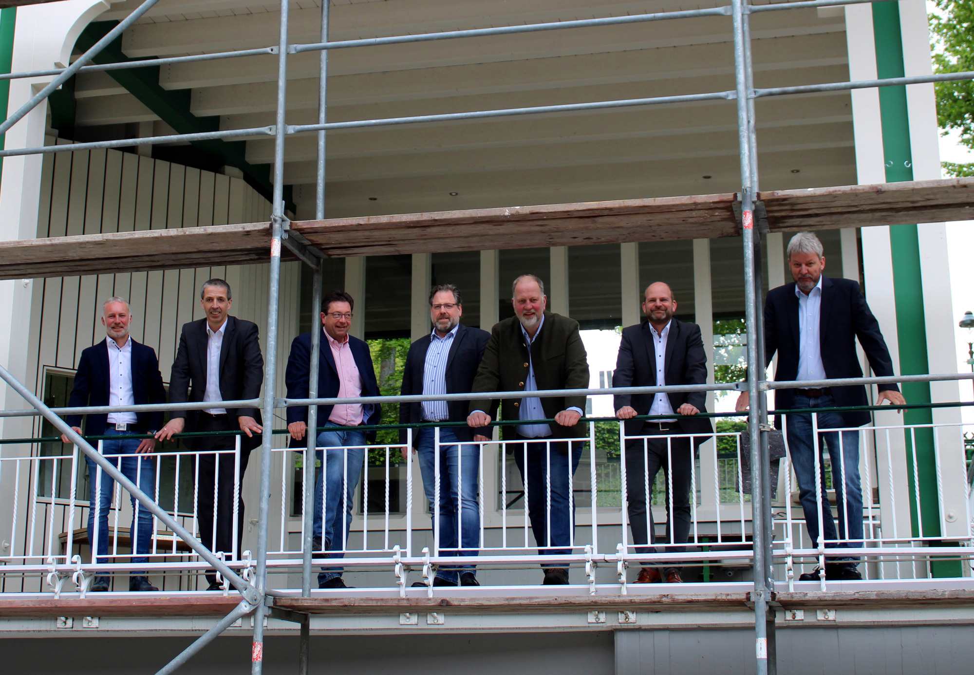 Noch steht am rechten Teil des Musikpavillons ein Gerüst. Bis zum Schützenfest sollen die Hagelschäden auf dem Dach beseitigt sein. Presseoffizier Leutnant Simon Niklas, Oberleutnant Peter Kliche, Schützenmajor Peter Liese, Schützenhauptmann Holger Harnischmacher und die Oberleutnante Frank Clemens, Andreas Roll und Christoph Schneider (v.l.) stellten in der Pressekonferenz vor dem Hochfest Neues und Bewährtes vor. Foto: mari Noch steht am rechten Teil des Musikpavillons ein Gerüst. Bis zum Schützenfest sollen die Hagelschäden auf dem Dach beseitigt sein. Presseoffizier Leutnant Simon Niklas, Oberleutnant Peter Kliche, Schützenmajor Peter Liese, Schützenhauptmann Holger Harnischmacher und die Oberleutnante Frank Clemens, Andreas Roll und Christoph Schneider (v.l.) stellten in der Pressekonferenz vor dem Hochfest Neues und Bewährtes vor. Foto: mari
